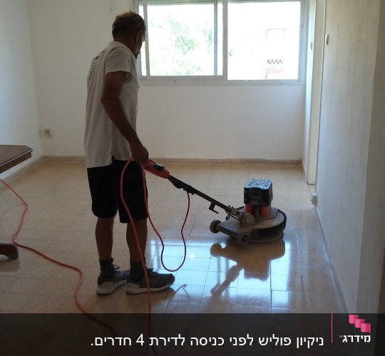 אדם מנקה רצפה עם מכונת פוליש חשמלית